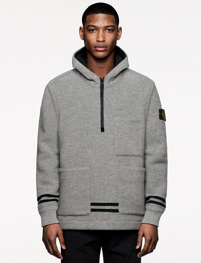 Model wearing gray, hooded sweatshirt with black stripes, two horizontal pockets and a third at left chest and zipper fastening at chest.