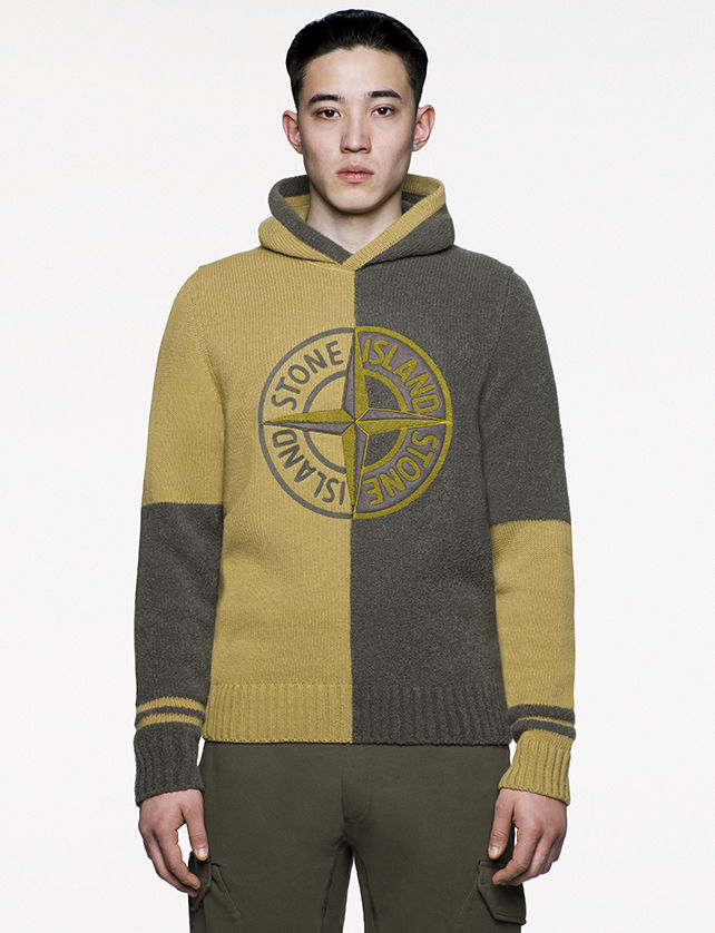 Model wearing green and mustard, hooded sweater with the Stone Island Compass logo at chest.