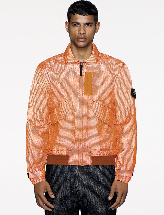 Model wearing orange bomber jacket in jacquard fabric.