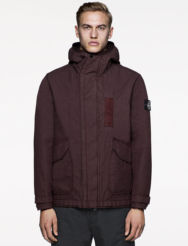 Model wearing maroon jacket with stand up collar, large diagonal bellows pockets and off center zipper fastening.