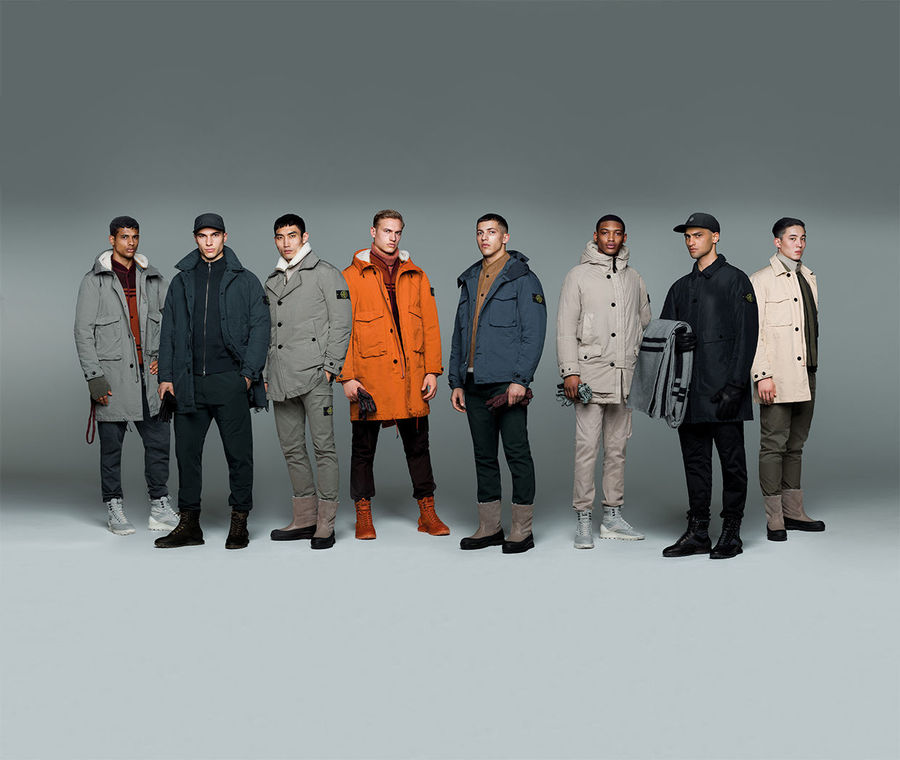 Eight models wearing Stone Island jackets, pants and caps in different styles and colors.