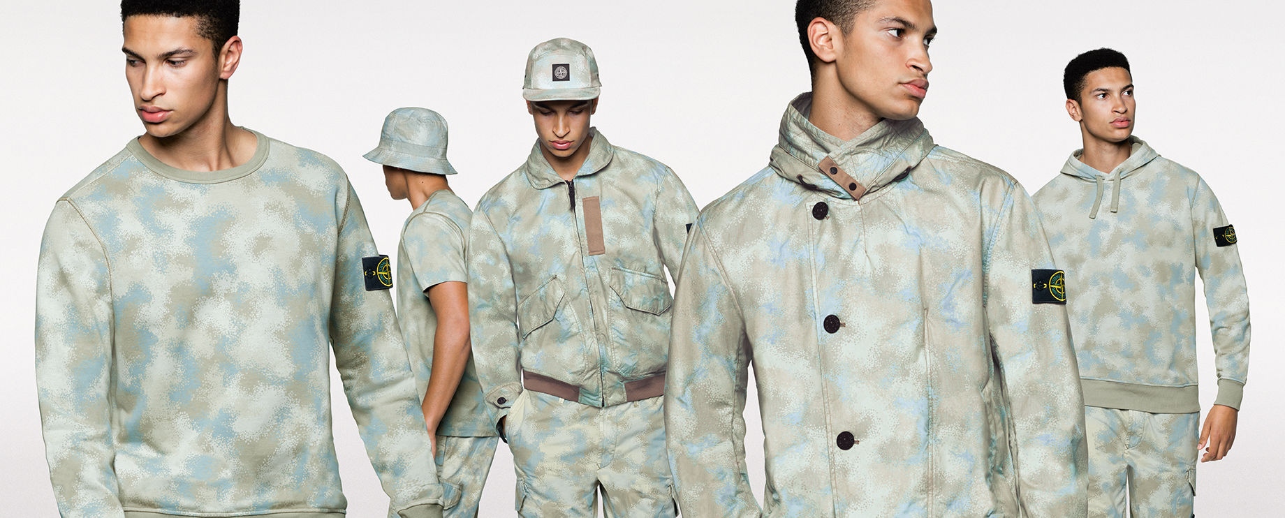 Five shots of the same model, showing the front and side view of him wearing different styles of sweatshirts, pants, shorts, jackets, hats and a t shirt, all in the same khaki and light blue camouflage print.