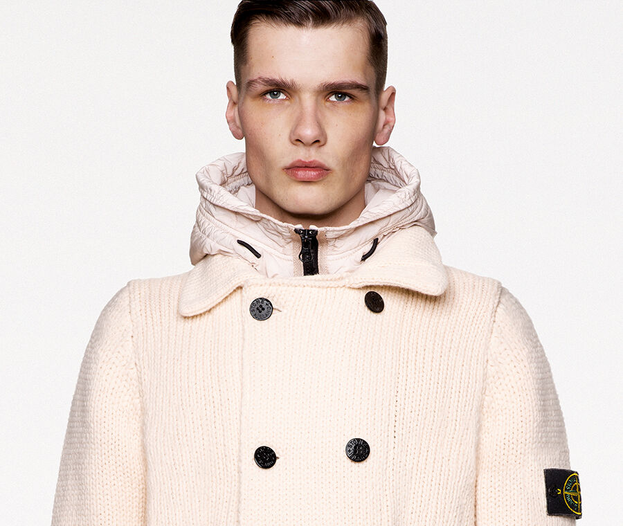 Model wearing beige check and paint splatter print pants and a matching crewneck sweatshirt with low shoulder line, ribbed neckline, cuffs and bottom band.