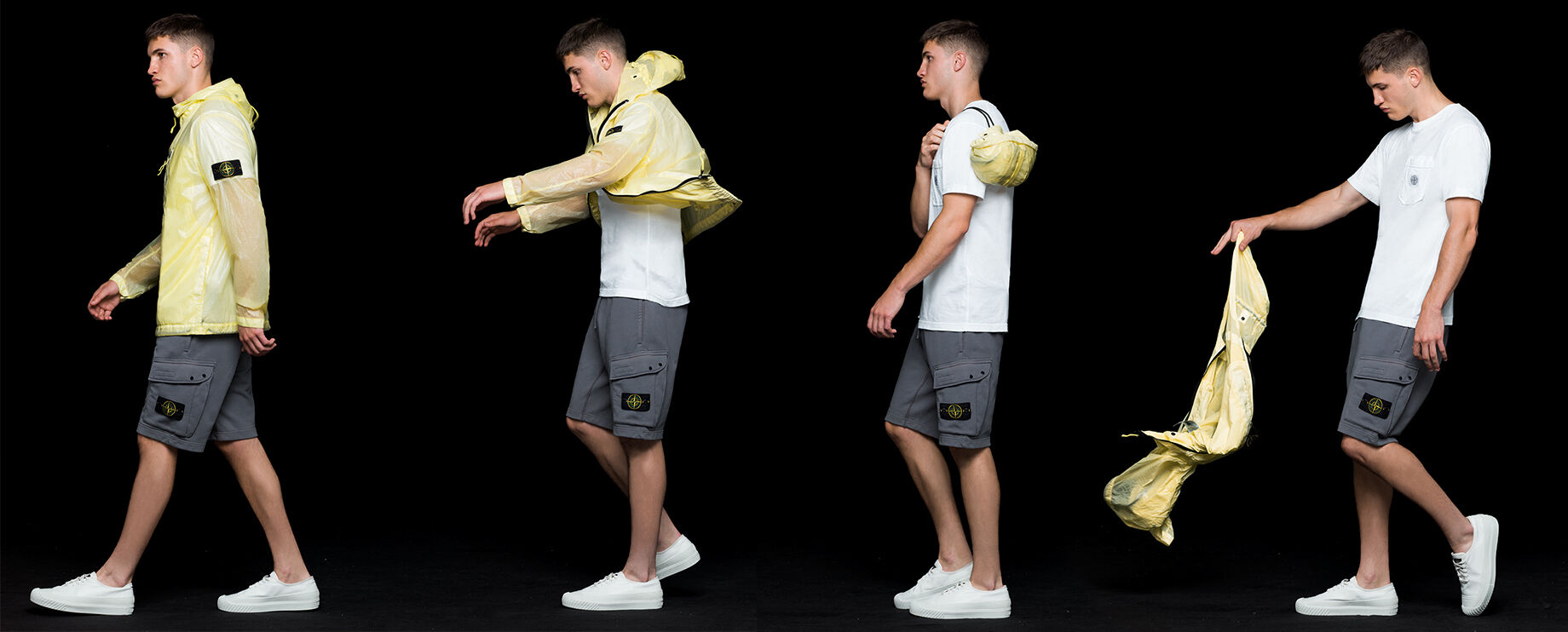 Four shots of the same model wearing gray cargo shorts, a white crewneck T shirt and a yellow see through hooded jacket with shiny effect, showing that the jacket is pocketable and can be stored in a carrying pouch.