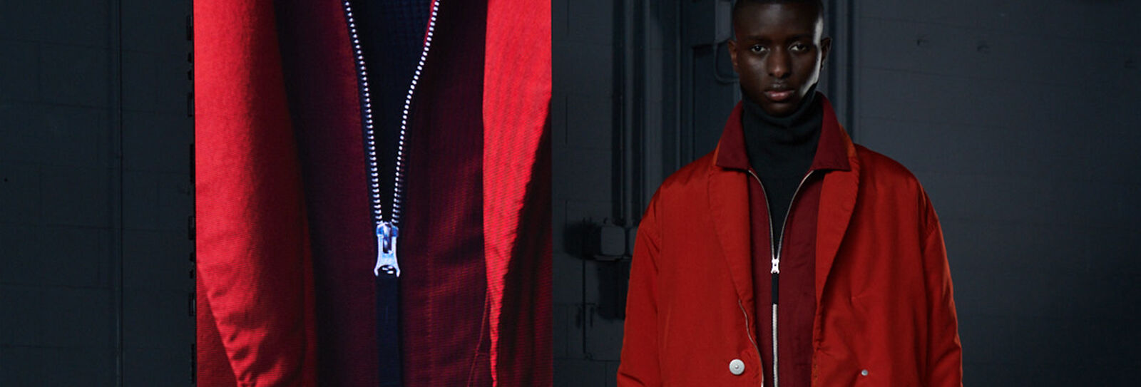 Model wearing a dark red jacket with high collar and a red overcoat beside an extreme close-up of the jacket zipper.