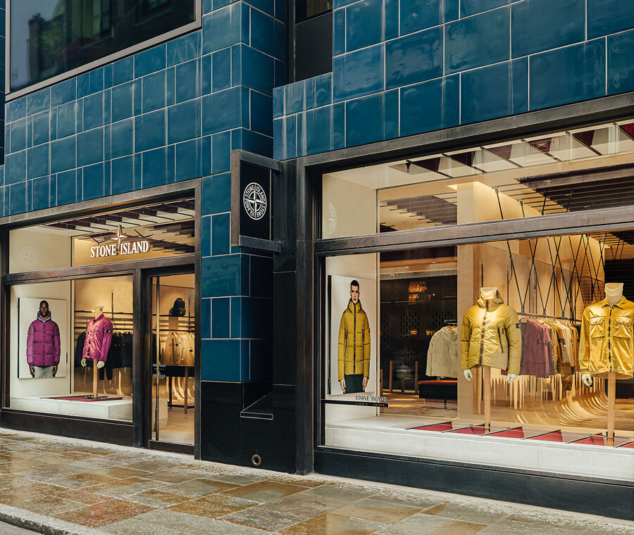 Angled view of storefront with three window displays of various jackets.