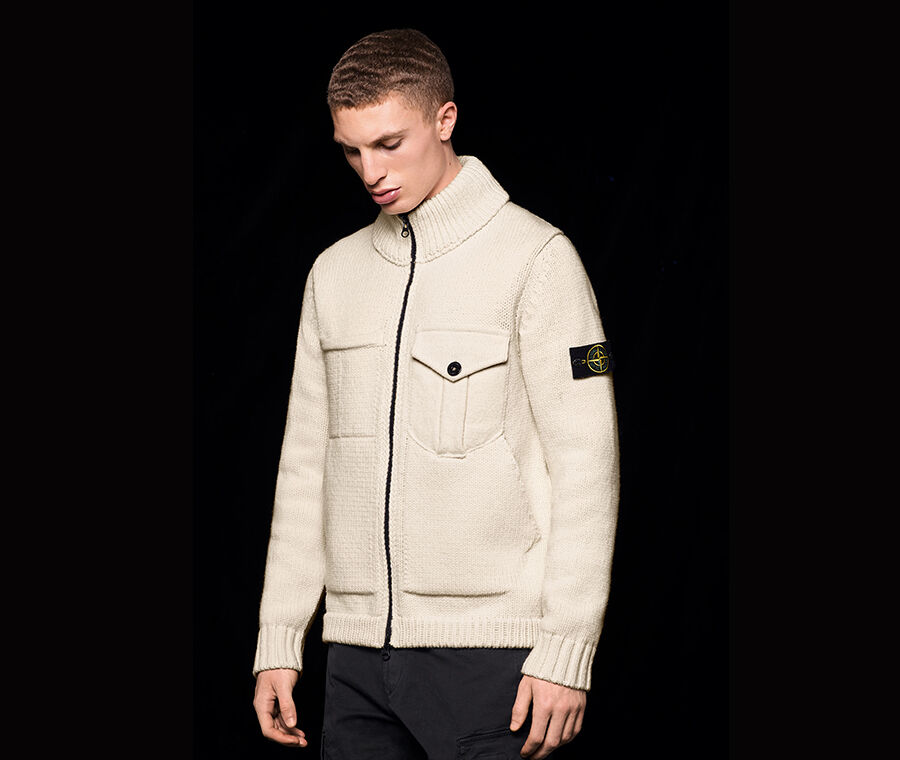 Model wearing a knit sweater with black zipper, one chest pocket featuring flap and button fastening; ribbed cuffs, hem and collar and the Stone Island badge on the upper left sleeve.
